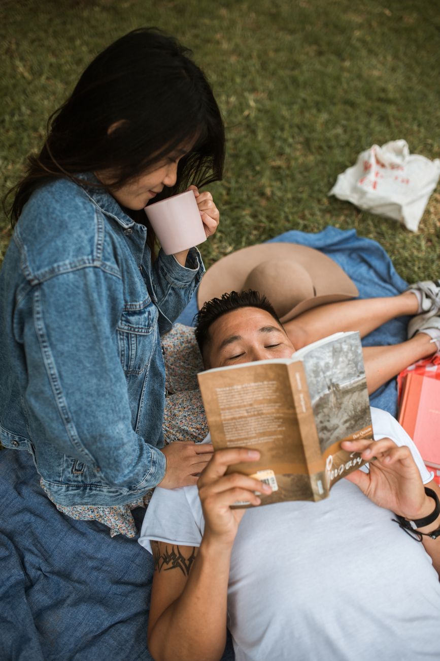 屋外で本を読みながらくつろぐ人