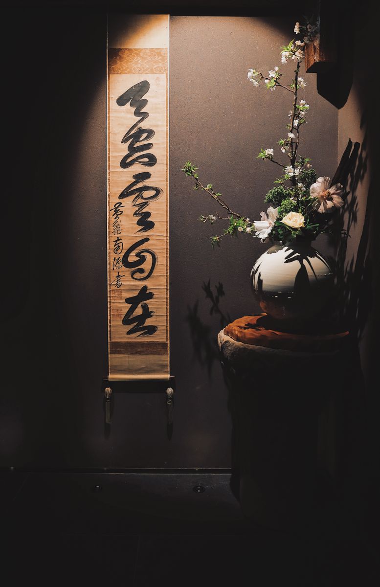 床の間に掛けられた書の掛け軸と生け花
