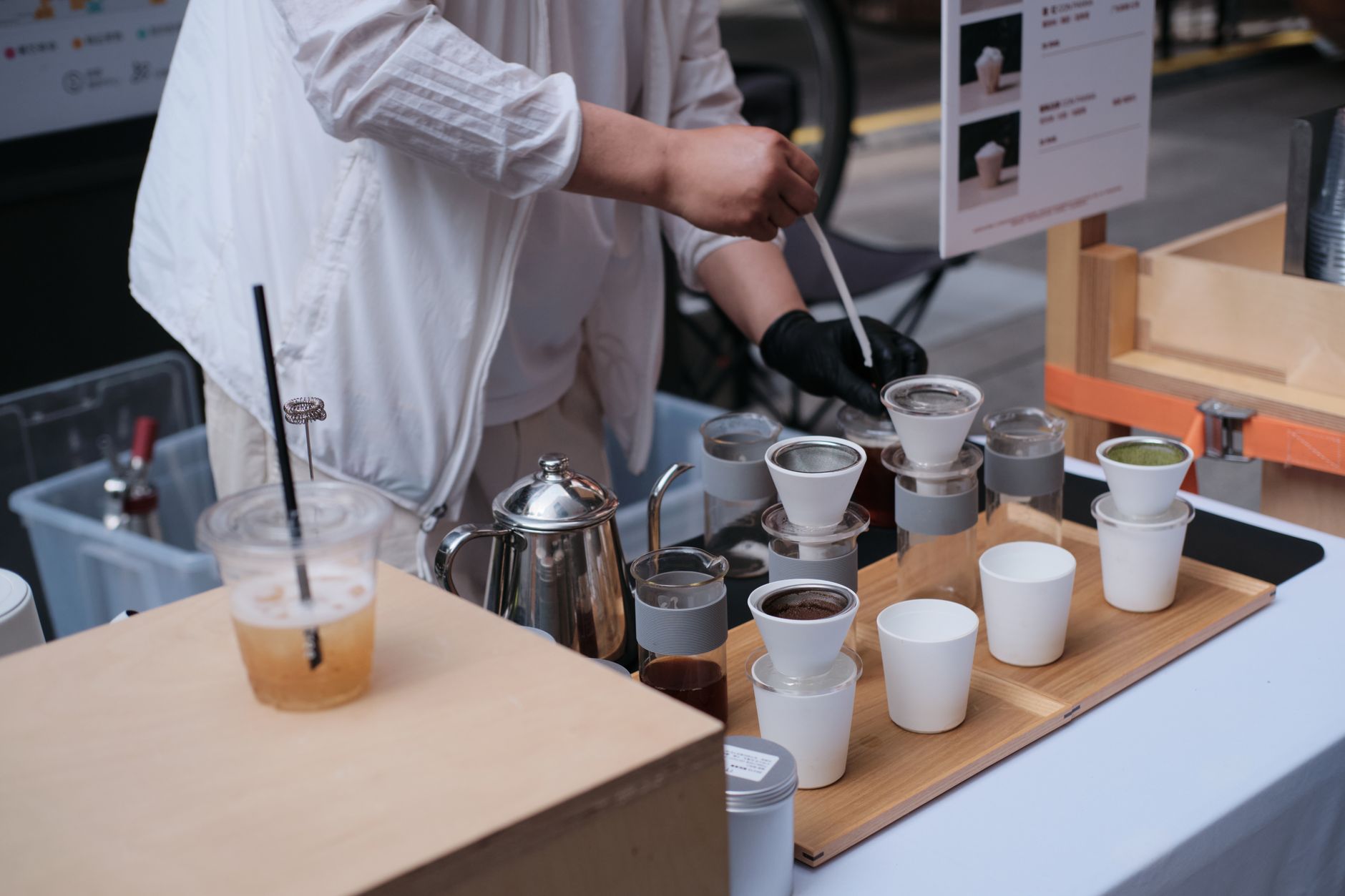 屋外のコーヒーイベントでハンドドリップを提供するバリスタ