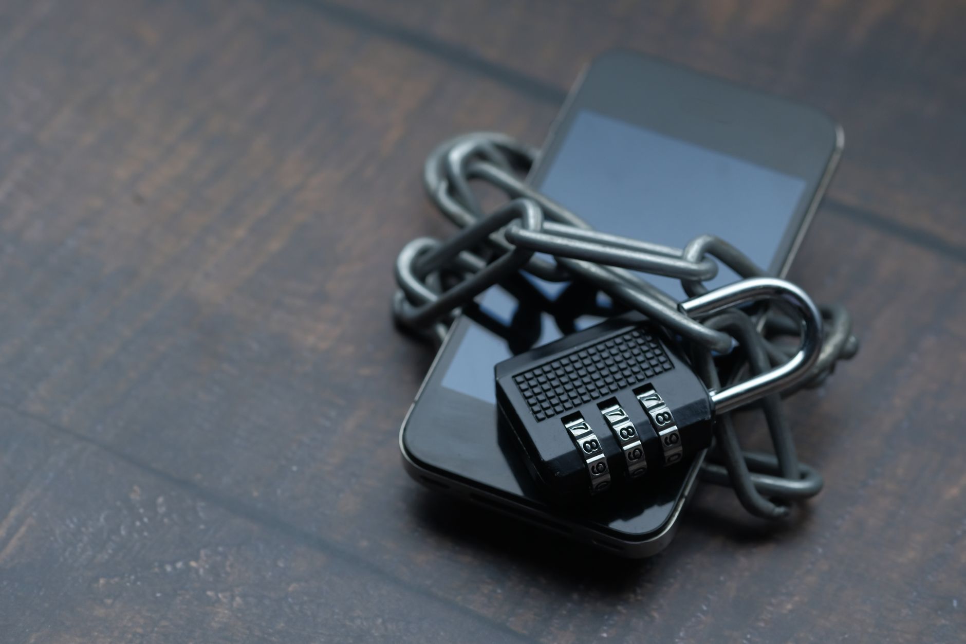 チェーンと南京錠が巻かれたスマートフォン