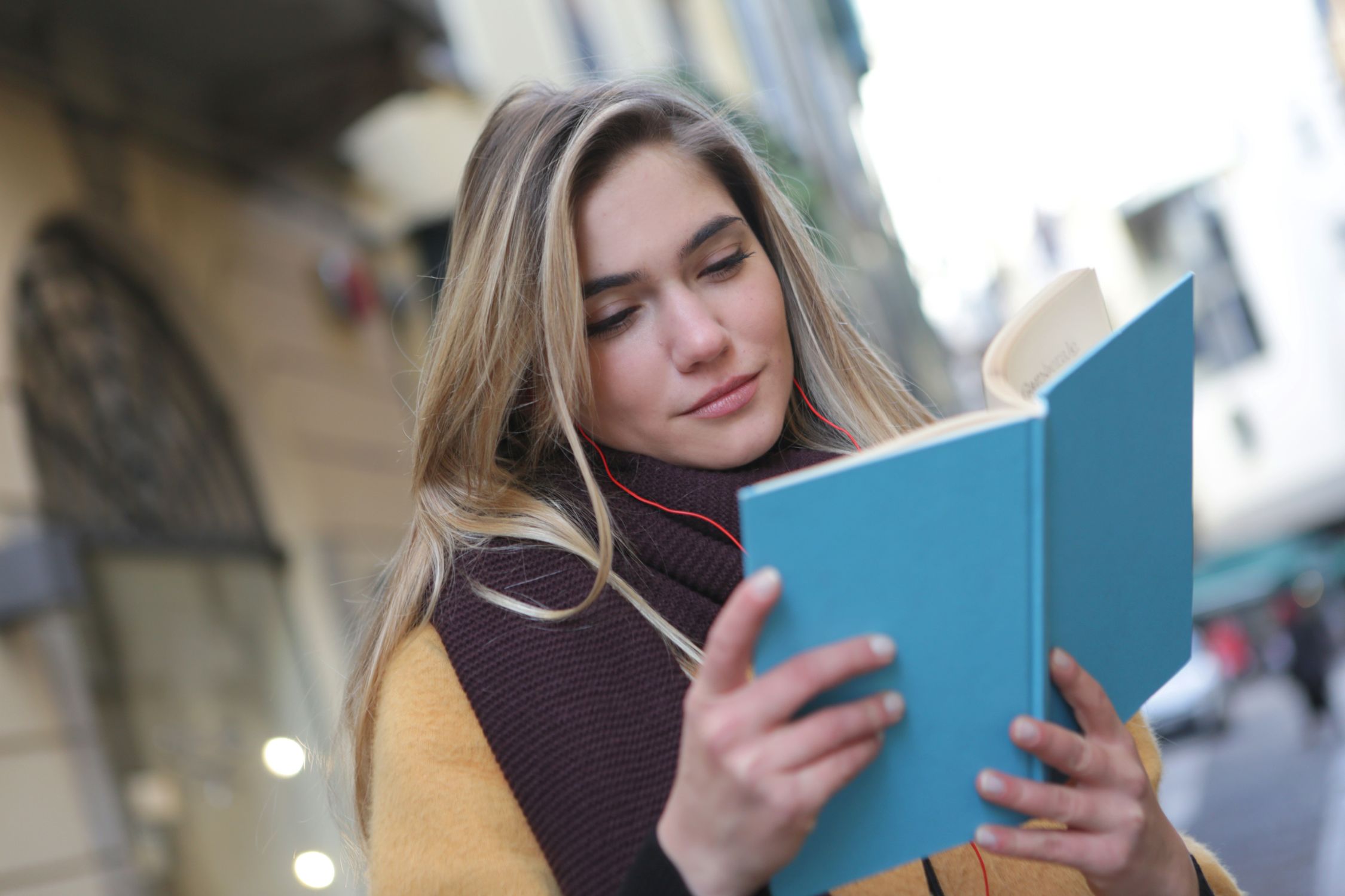街角で本を読む若い女性