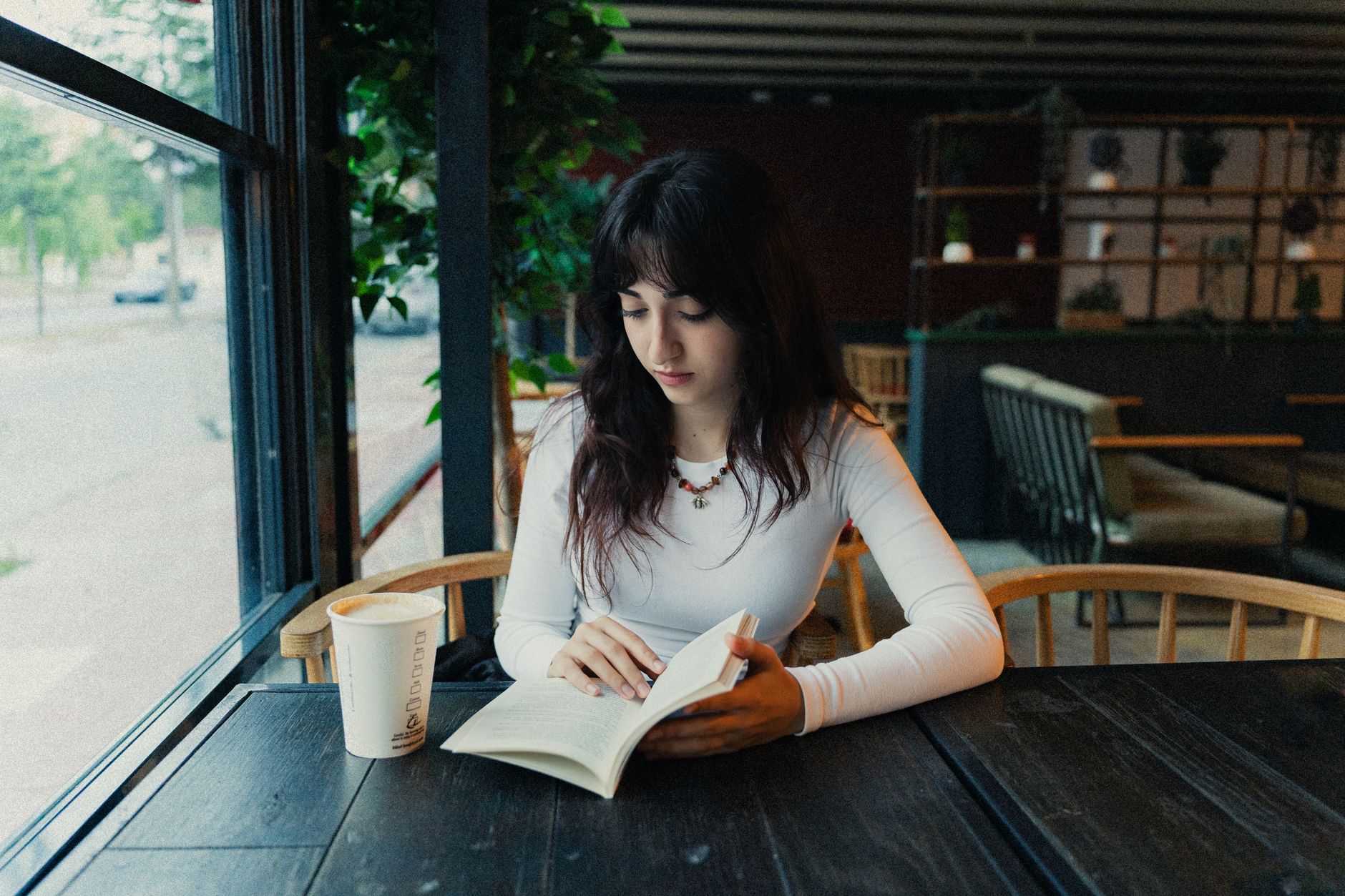 カフェで本を読みながらくつろぐ女性