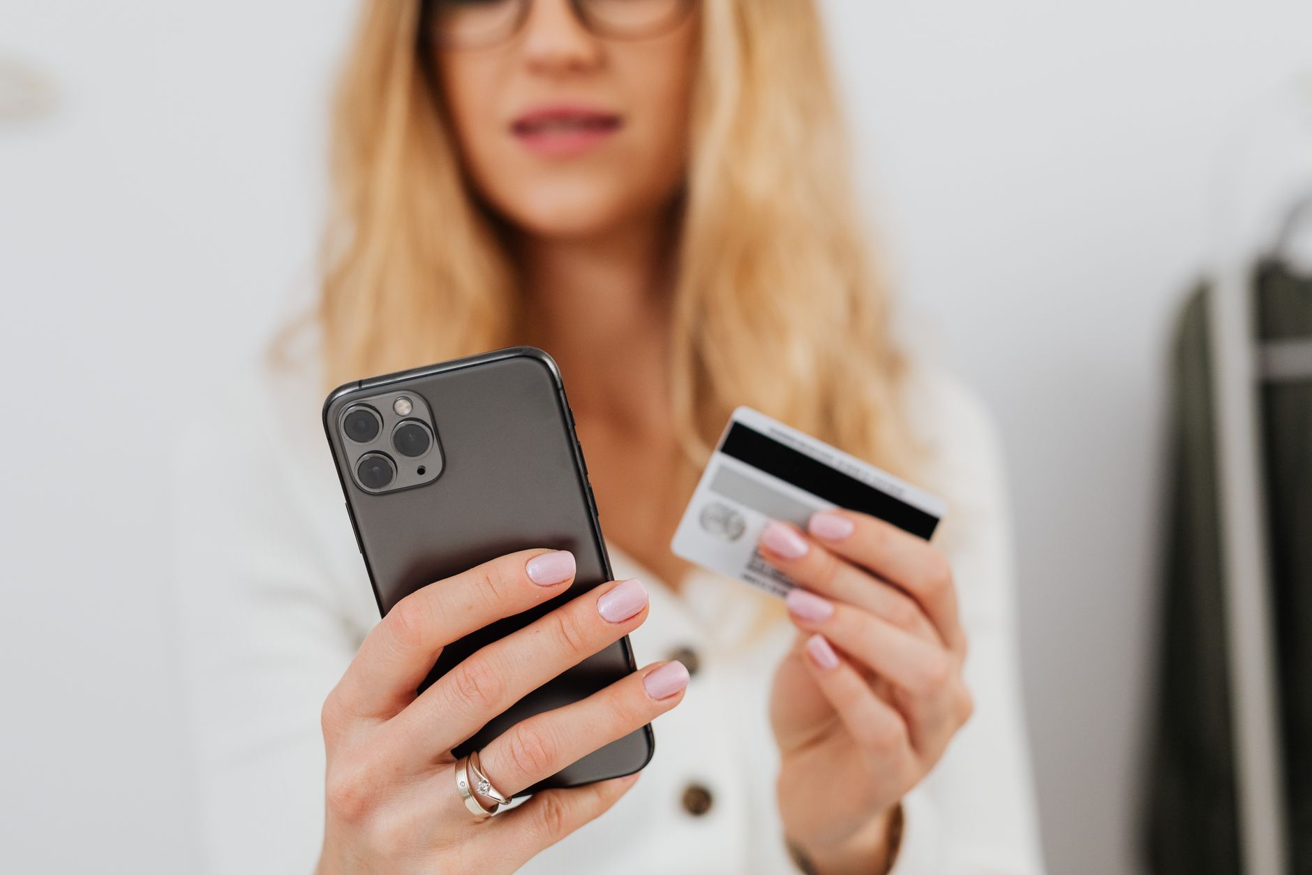 スマートフォンとクレジットカードでネット通販の支払いをする手元