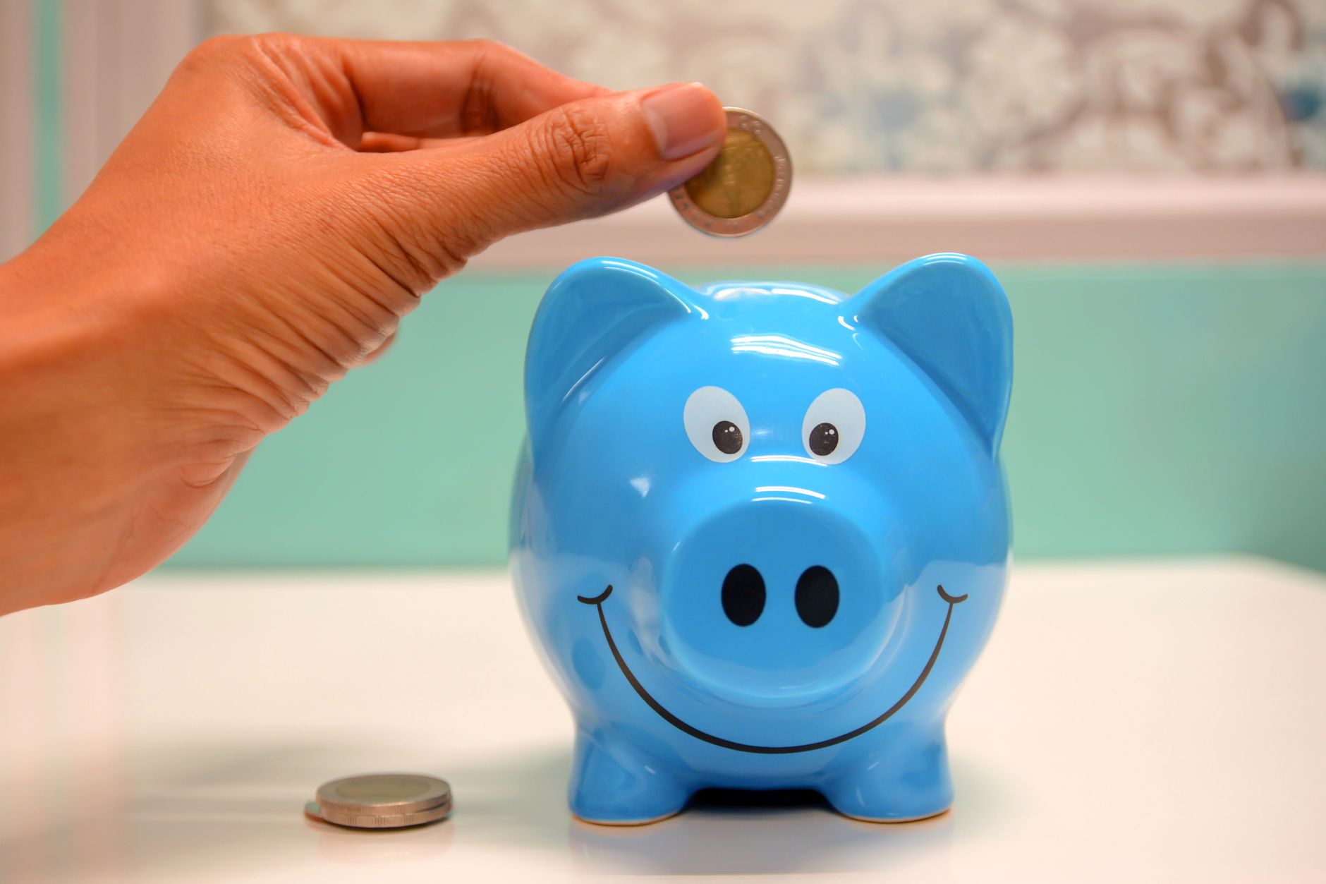 貯金箱とお金を見つめる親子のイメージ