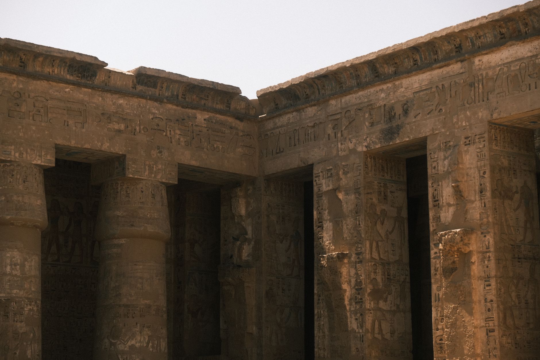 Close-up of ancient temple columns with hieroglyphs, showcasing historic architecture.