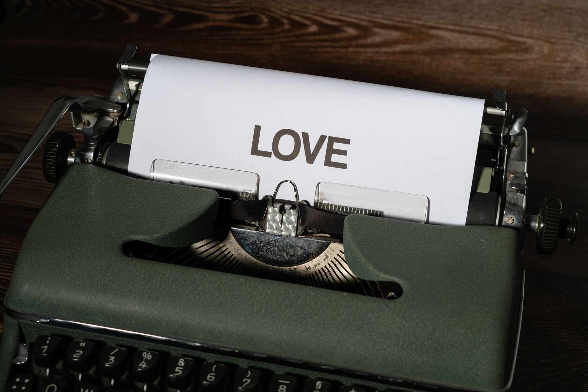 Close-up of a vintage typewriter with paper displaying the word 'Love'. Perfect for themes of nostalgia and romance.